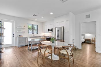 A kitchen and dining room with a table and chairs